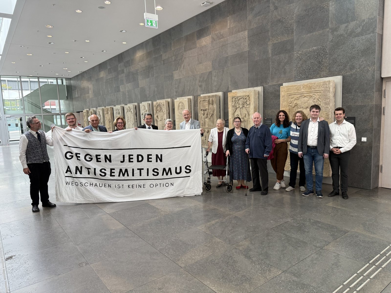 Gruppe mit dem Banner „Gegen jeden Antisemitismus – Wegschauen ist keine Option“